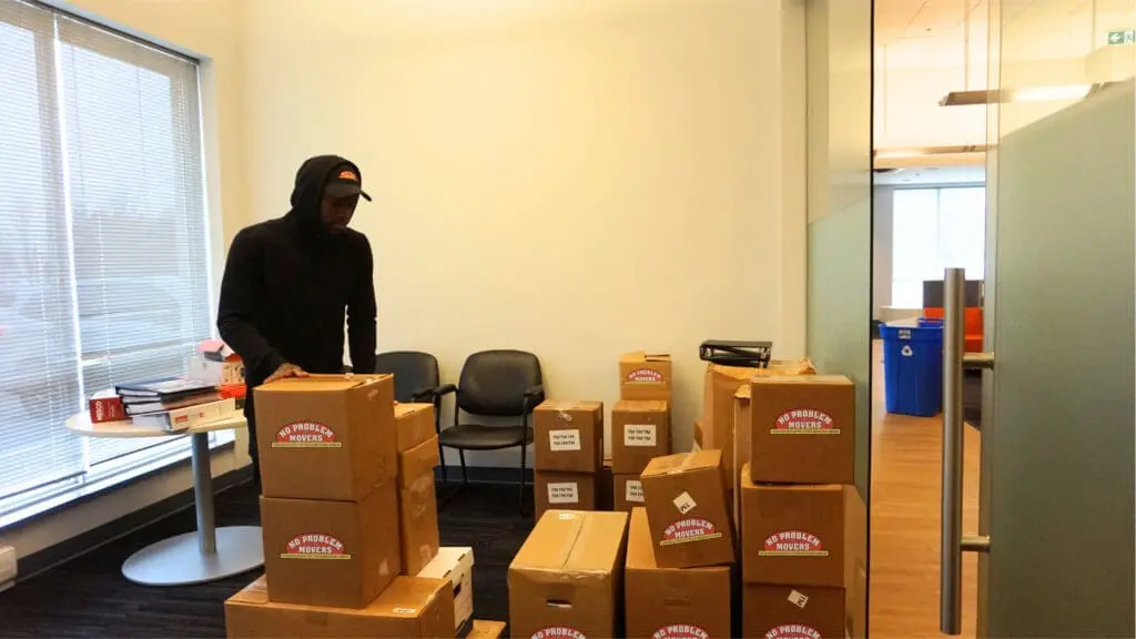 person packing office stuff into boxes